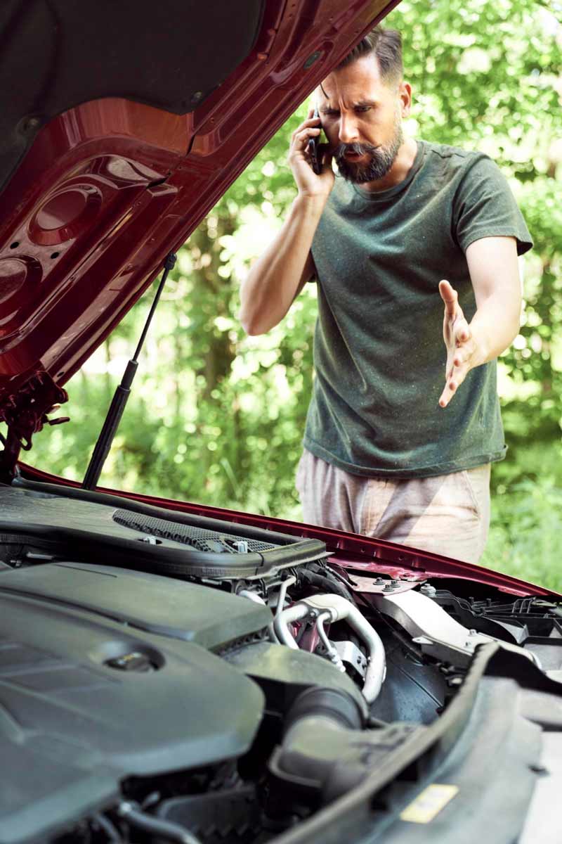 Junger Mann prüft Getriebeschaden bei Schrottauto Ankauf Erkrath